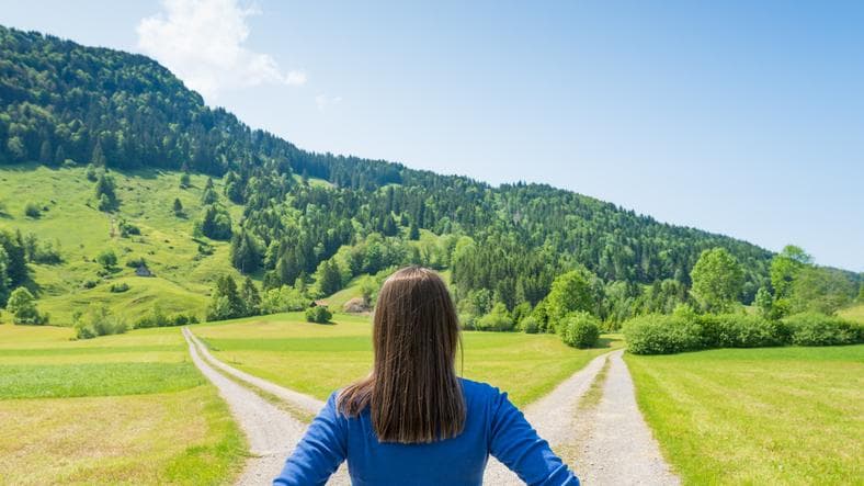 Woman standing at a fork in the road 